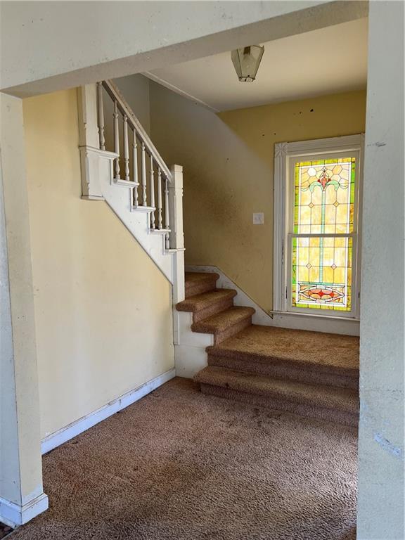 stairs featuring carpet and baseboards