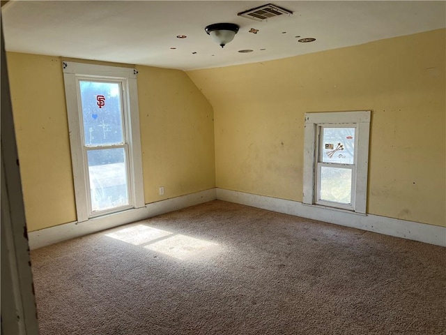 additional living space featuring lofted ceiling, carpet flooring, and visible vents