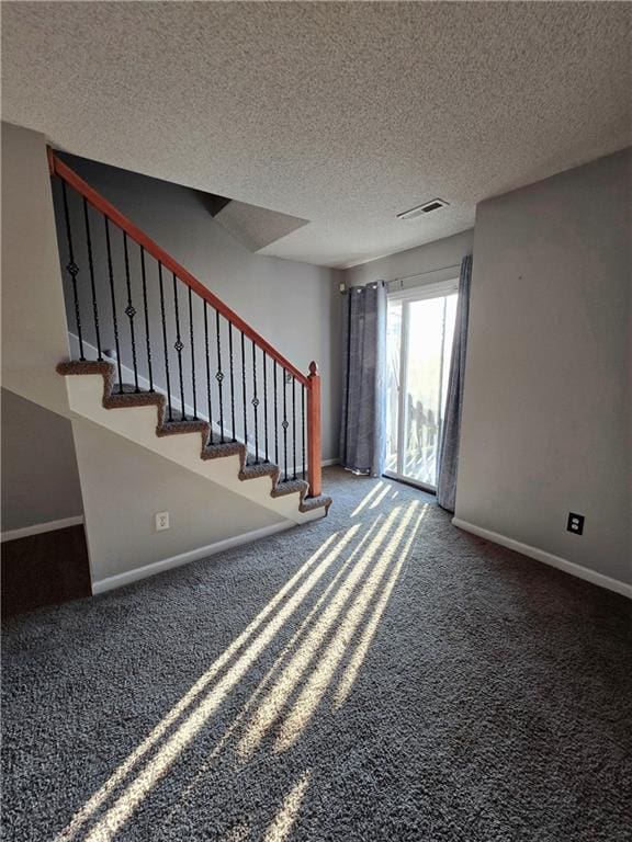 unfurnished living room featuring visible vents, carpet flooring, stairway, and baseboards