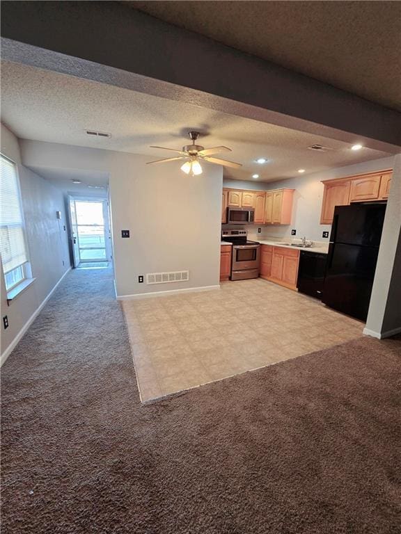 kitchen featuring visible vents, light carpet, black appliances, and light brown cabinets