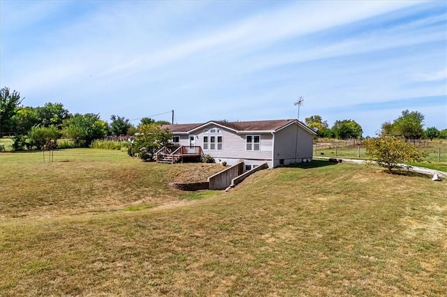 rear view of house featuring a wooden deck and a yard