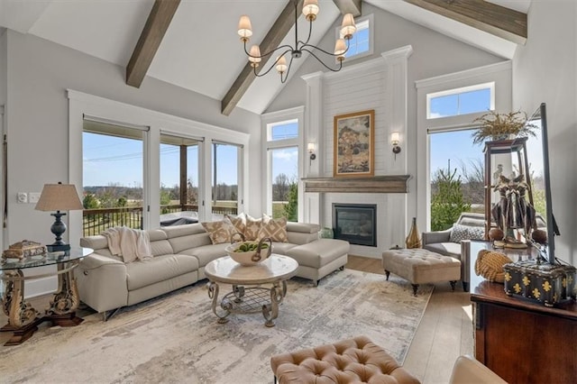 living area with beam ceiling, plenty of natural light, a fireplace, and high vaulted ceiling