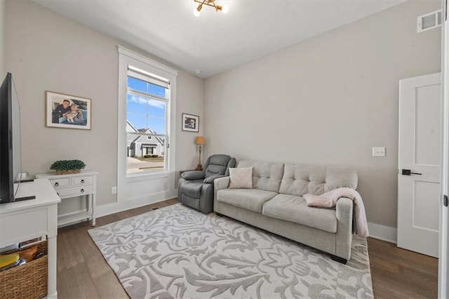 living area featuring wood finished floors, visible vents, and baseboards