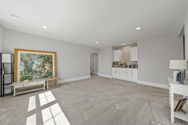 unfurnished living room featuring recessed lighting, visible vents, baseboards, and light carpet