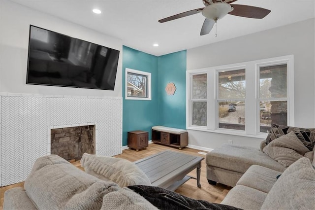 living room with baseboards, recessed lighting, a tile fireplace, wood finished floors, and a ceiling fan