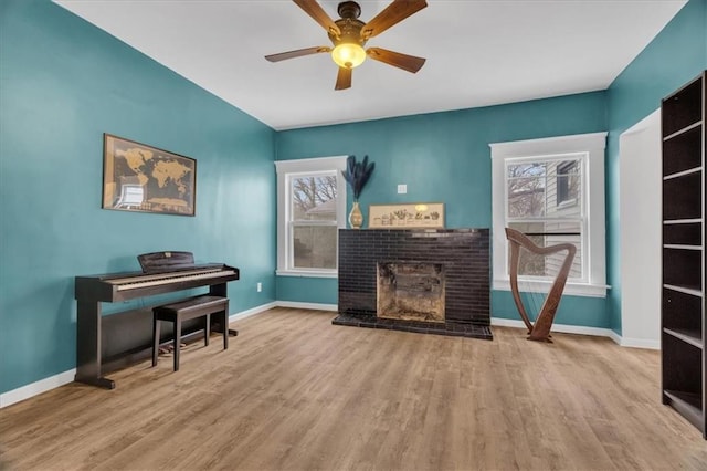 living area featuring wood finished floors, a fireplace, and baseboards