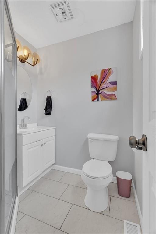 bathroom featuring visible vents, toilet, vanity, and baseboards