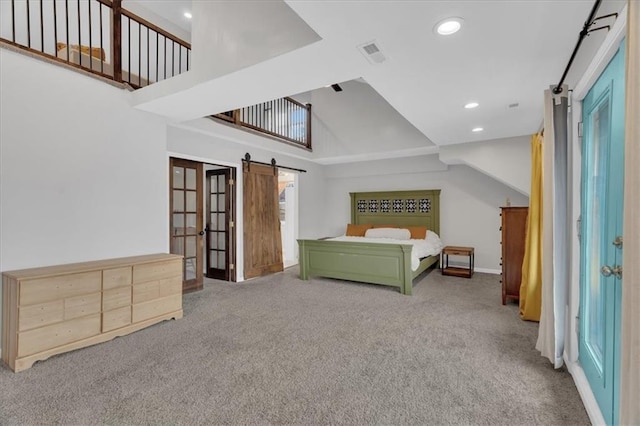 unfurnished bedroom with visible vents, carpet, a barn door, recessed lighting, and a high ceiling