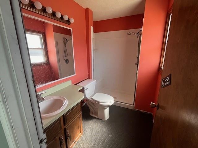 full bathroom featuring toilet, walk in shower, and vanity