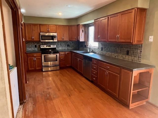 kitchen featuring dark countertops, stainless steel appliances, and a sink