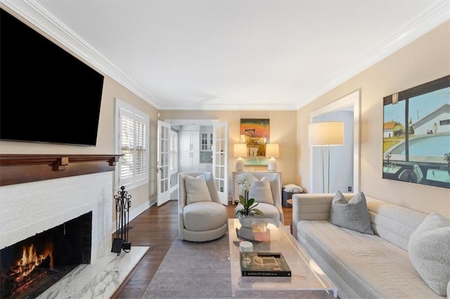 living area featuring baseboards, wood finished floors, a warm lit fireplace, and ornamental molding