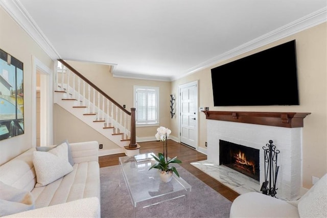 living room with a fireplace with flush hearth, ornamental molding, and wood finished floors