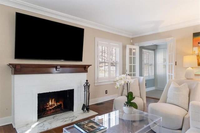 living room featuring wood finished floors, baseboards, and ornamental molding