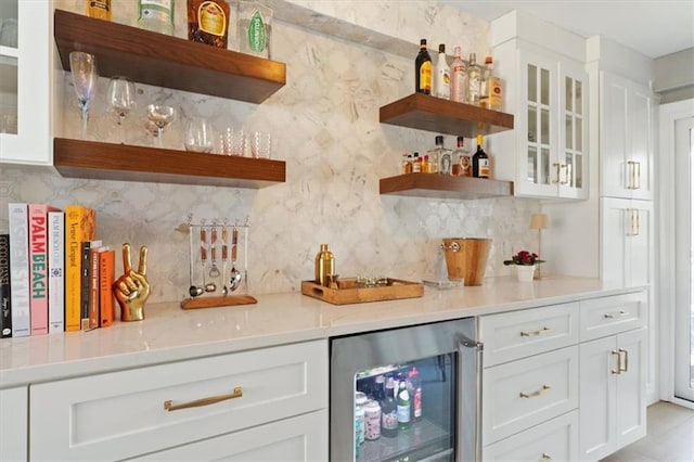 bar featuring wine cooler, tasteful backsplash, and a dry bar