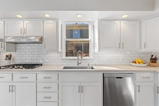 kitchen featuring under cabinet range hood, light countertops, appliances with stainless steel finishes, white cabinets, and a sink