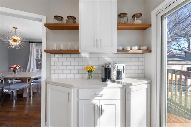 kitchen with decorative backsplash, white cabinets, light countertops, and open shelves