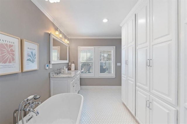 bathroom with a freestanding tub, baseboards, ornamental molding, and vanity