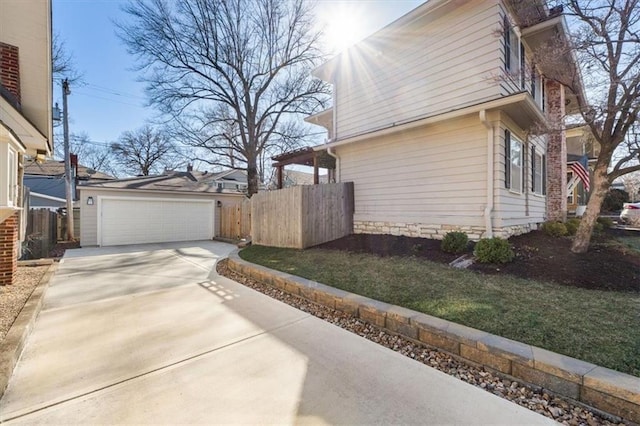 view of property exterior with a garage, concrete driveway, and fence