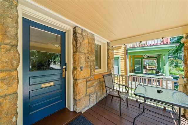 property entrance featuring covered porch and stone siding