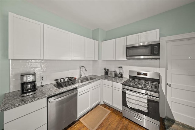 kitchen with white cabinets, backsplash, appliances with stainless steel finishes, and a sink