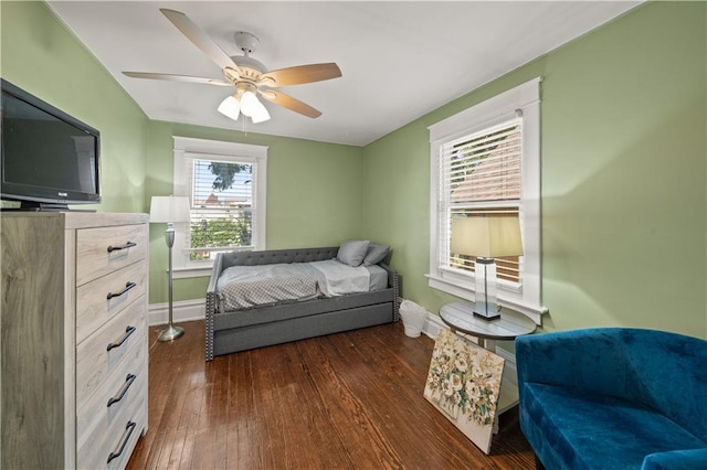 bedroom with a ceiling fan, baseboards, and dark wood-style flooring