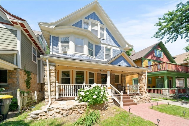 victorian-style house with fence and covered porch