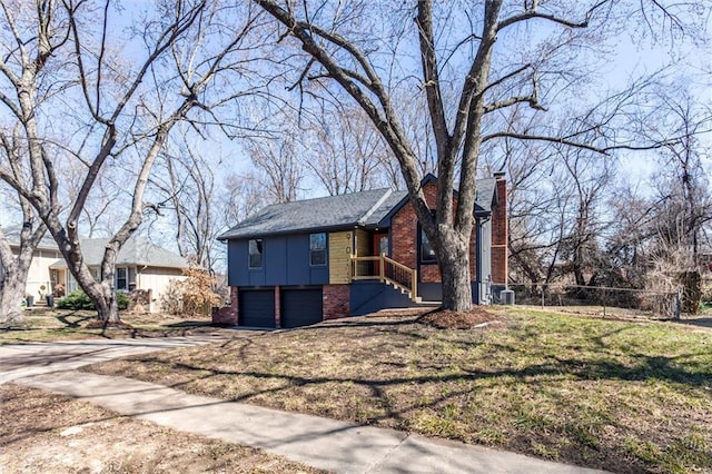 view of front facade featuring driveway, fence, a garage, brick siding, and a chimney