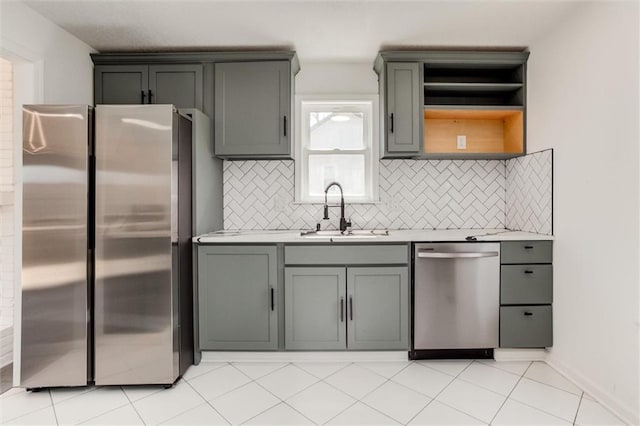 kitchen with a sink, decorative backsplash, appliances with stainless steel finishes, and light countertops