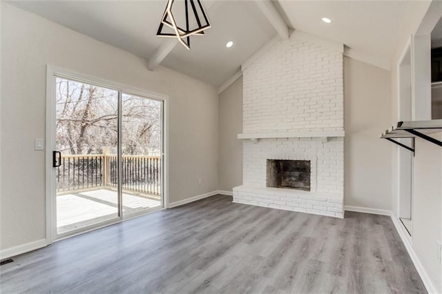 unfurnished living room featuring a brick fireplace, baseboards, lofted ceiling with beams, recessed lighting, and wood finished floors