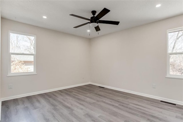 empty room featuring wood finished floors, baseboards, visible vents, recessed lighting, and ceiling fan