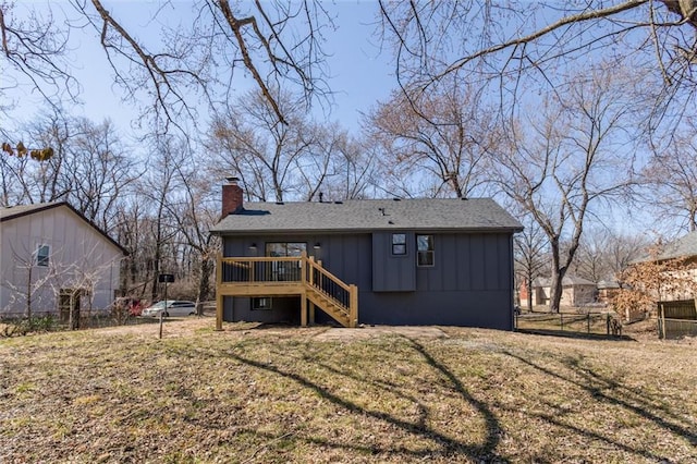 back of house with board and batten siding, fence, a wooden deck, stairs, and a chimney