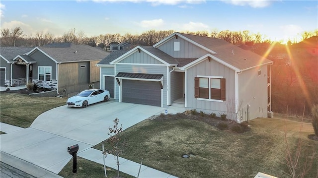 view of front of home with concrete driveway, an attached garage, board and batten siding, and a yard