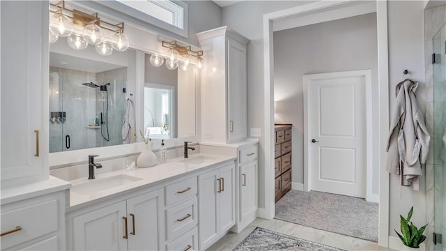 bathroom with double vanity, a stall shower, and a sink