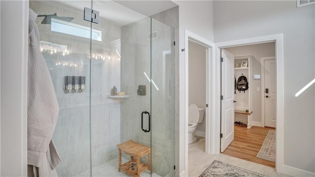 full bath with a shower stall, toilet, baseboards, and visible vents