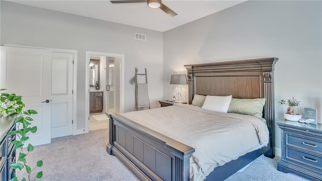 bedroom featuring a ceiling fan, light colored carpet, visible vents, and connected bathroom