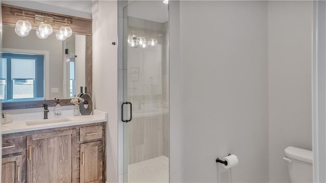 full bath featuring toilet, a stall shower, and vanity