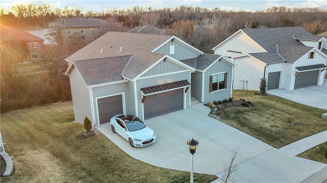 view of front of home featuring driveway, roof with shingles, board and batten siding, a front yard, and a garage