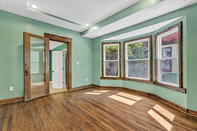 unfurnished room with recessed lighting, wood finished floors, and baseboards