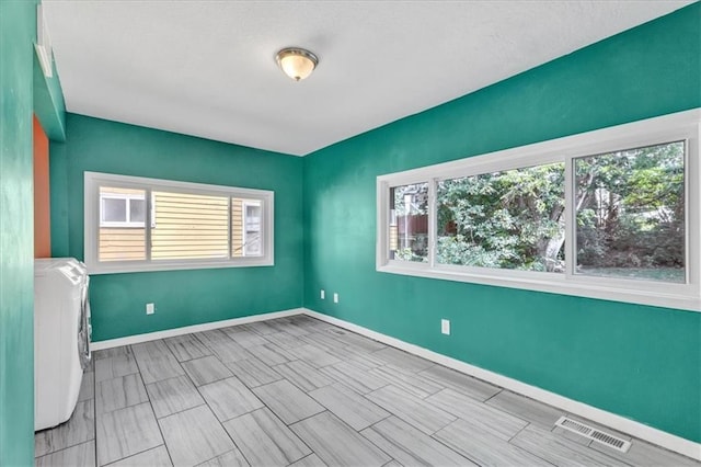 empty room featuring visible vents, baseboards, and washing machine and clothes dryer