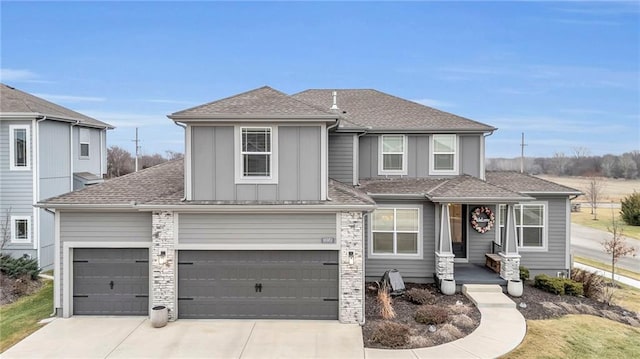 traditional-style home featuring a garage, board and batten siding, driveway, and a shingled roof