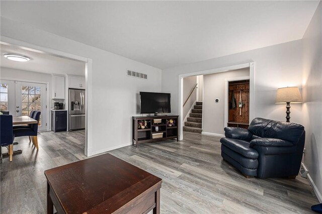 1008 Bristol Way, Liberty, MO 64068 - living room featuring visible vents, light wood finished floors, baseboards, stairs, and french doors