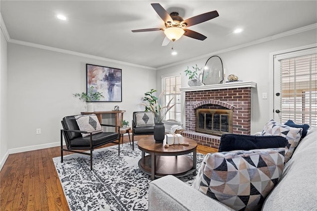 living area with baseboards, wood finished floors, and ornamental molding