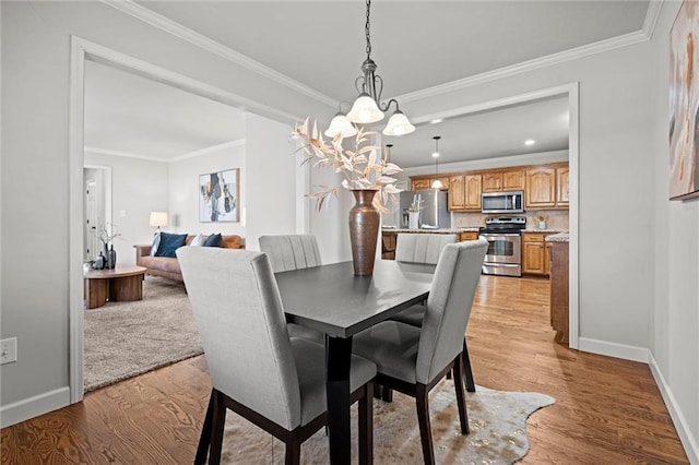 dining area with recessed lighting, light wood-style flooring, crown molding, and baseboards