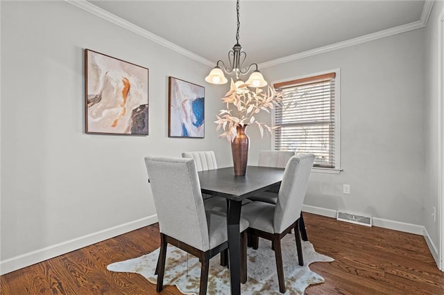 dining area featuring crown molding, wood finished floors, visible vents, and baseboards