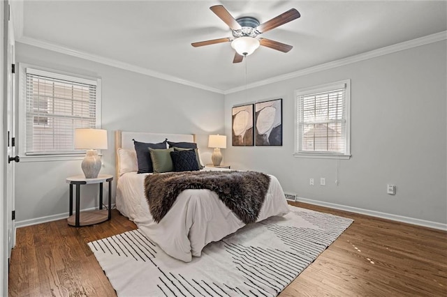 bedroom featuring ceiling fan, crown molding, baseboards, and wood finished floors