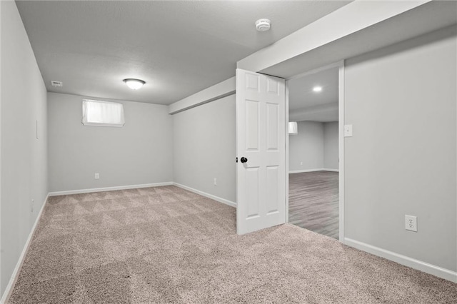 basement with visible vents, baseboards, and carpet floors