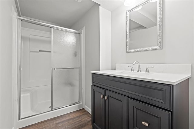 full bathroom with a stall shower, vanity, and wood finished floors