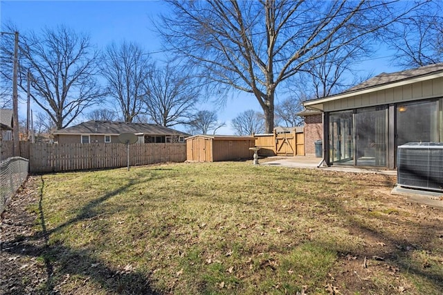 view of yard featuring an outbuilding, central AC unit, a storage shed, and a fenced backyard