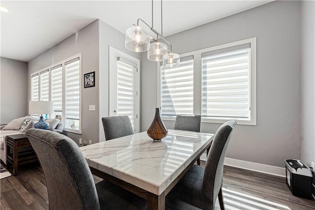 dining area with a notable chandelier, baseboards, and dark wood-style flooring