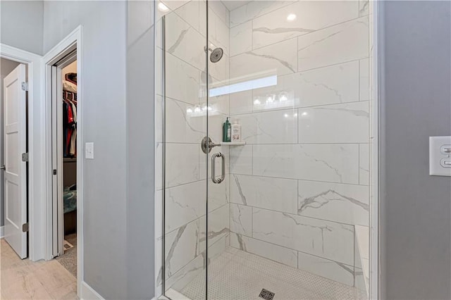 full bathroom with a walk in closet and a shower stall